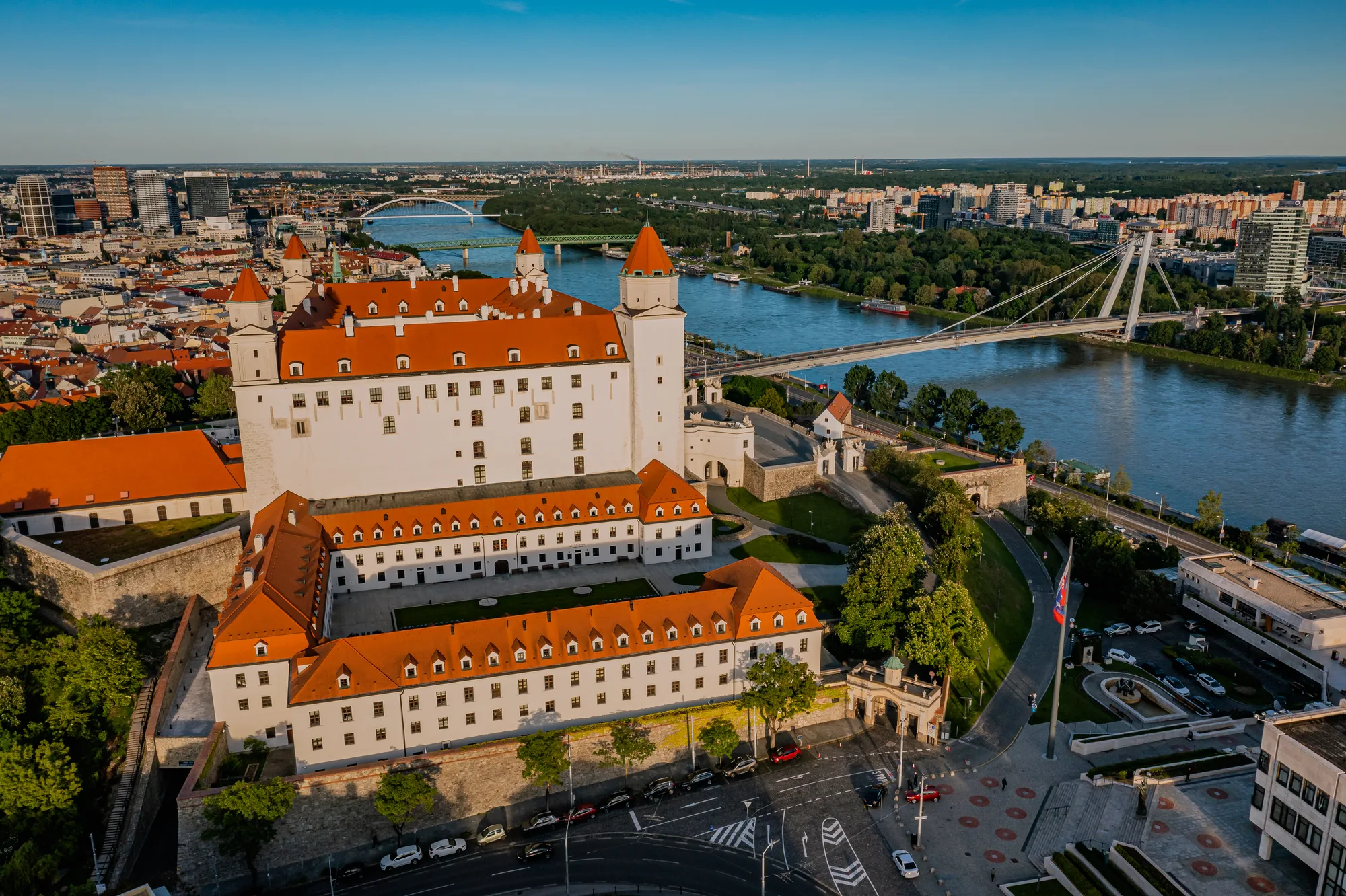 Aerial view of Bratislava Castle — a white four-towered palace on the hill above the Danube