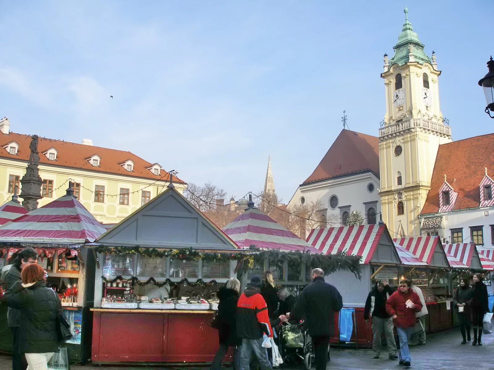 Wooden stalls of the Bratislava Christmas market on the Main Square below the Old Town Hall tower